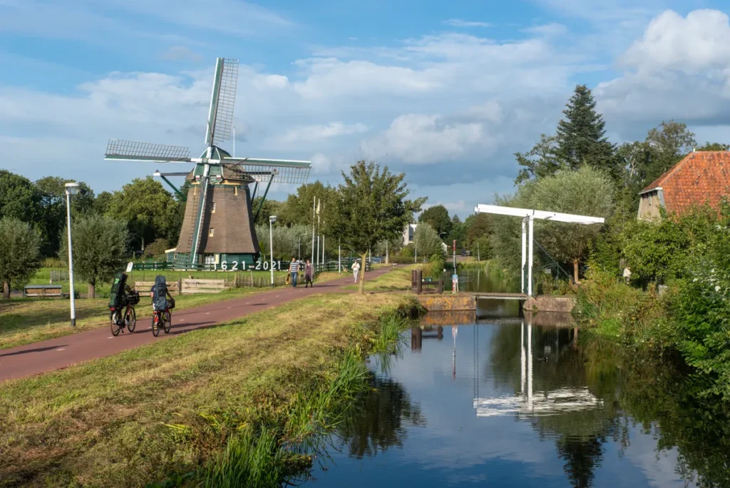 Nederlands landschap met een windmolen en fietsers